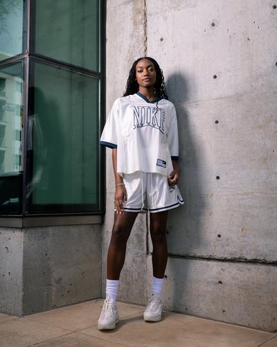 Woman standing in Nike Sportswear Street Short-Sleeve Graphic Jersey Top,  Nike Women's Sportswear Street 6" Satin Graphic Shorts, Nike Socks, and Nike Air Max 95 "Lt Orewood Brn/Phantom/Platinum Tint" Women's Shoe